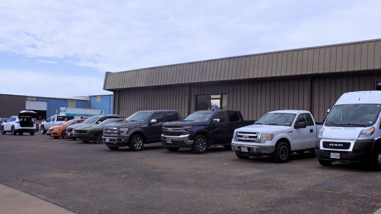 The United Auto Works building on Englewood Ave with customer vehicles parked along the front