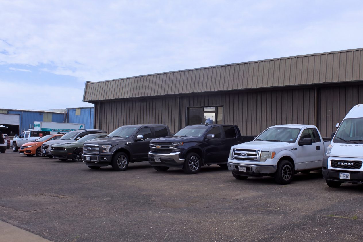 The United Auto Works building on Englewood Ave with customer vehicles parked along the front