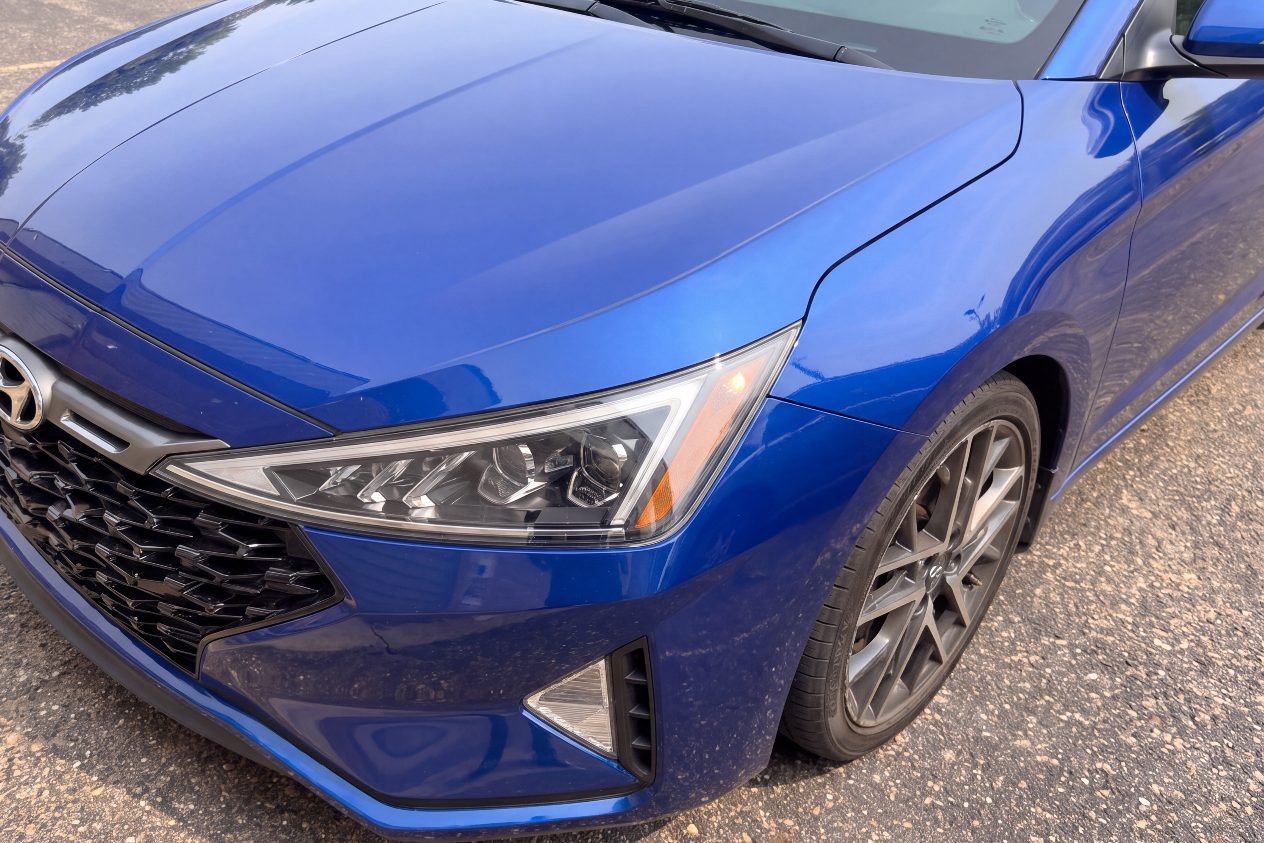 After: the same blue sedan with bumper, headlight and fender back in line