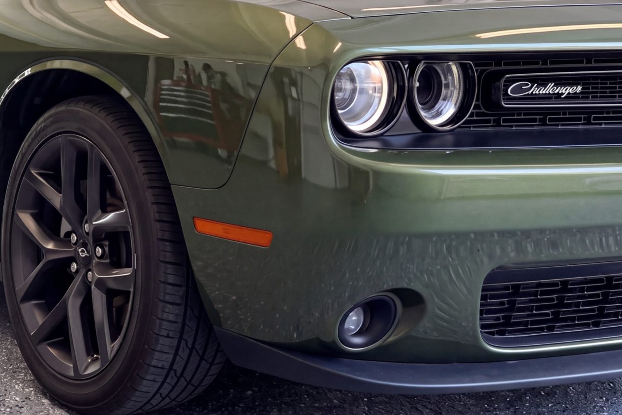 After: the same green coupe with the bumper repainted to match the body