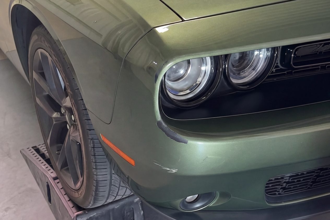 Before: the front bumper of a green coupe, the paint dull and scuffed